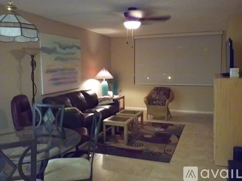 A living room with a couch, chair, and a painting on the wall.