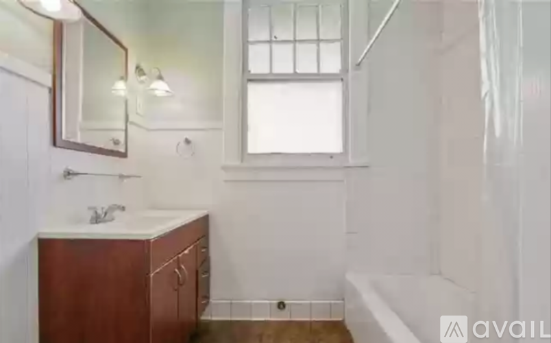A bathroom with a white tub, sink, and mirror.
