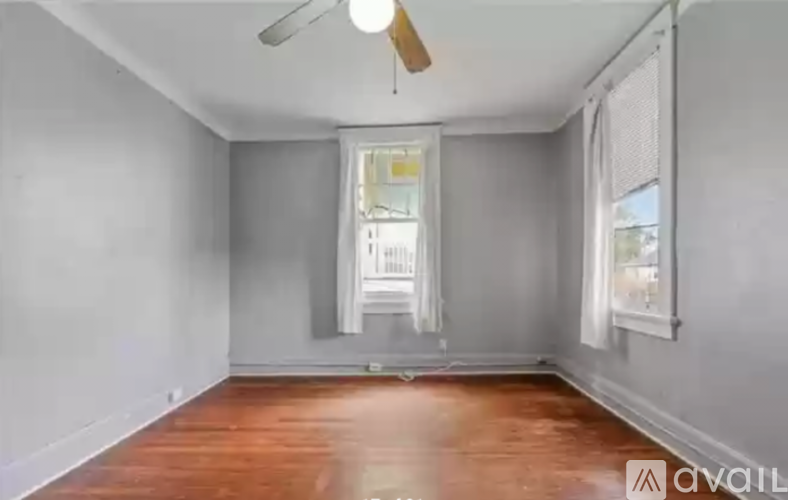 A room with wooden floors and a ceiling fan.