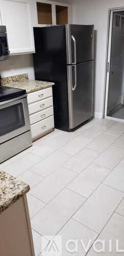 A kitchen with black and stainless steel appliances.