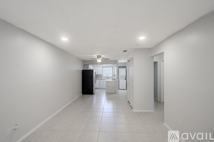 A spacious, empty room with white walls and a tiled floor.