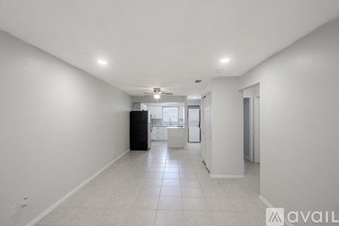 A spacious, empty room with white walls and a tiled floor.