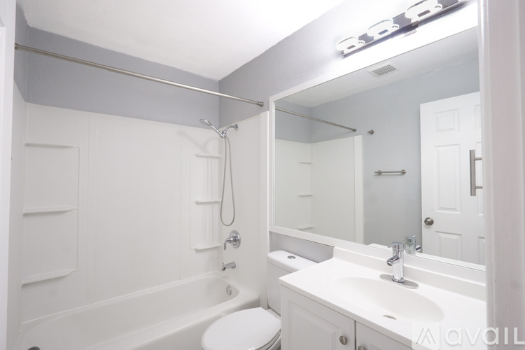 A white bathroom with a toilet, sink, and bathtub.
