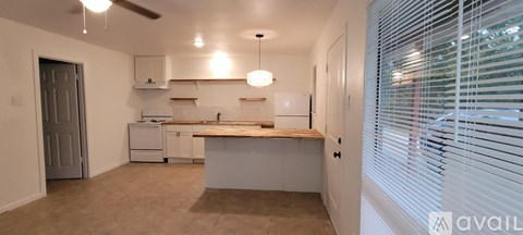 A kitchen with white appliances and a wooden countertop.