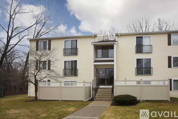 A two-story apartment building with a balcony on the second floor.