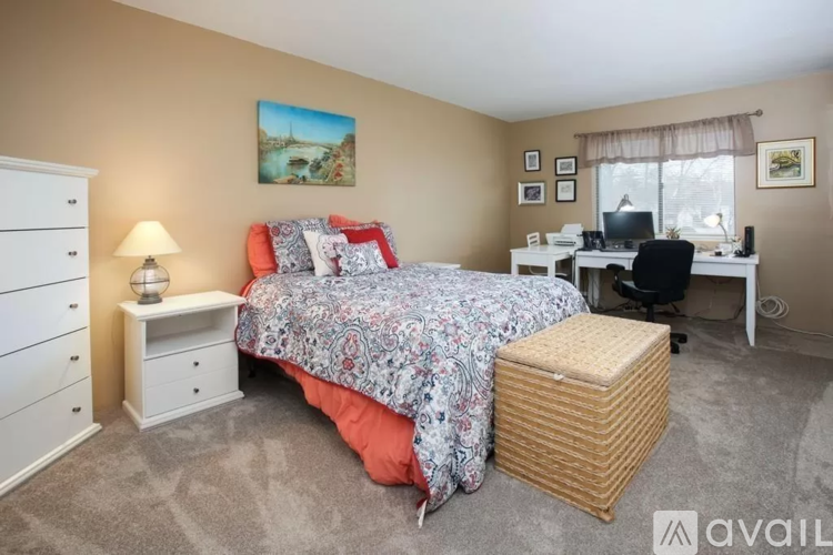 A bedroom with a bed, desk, and chair.