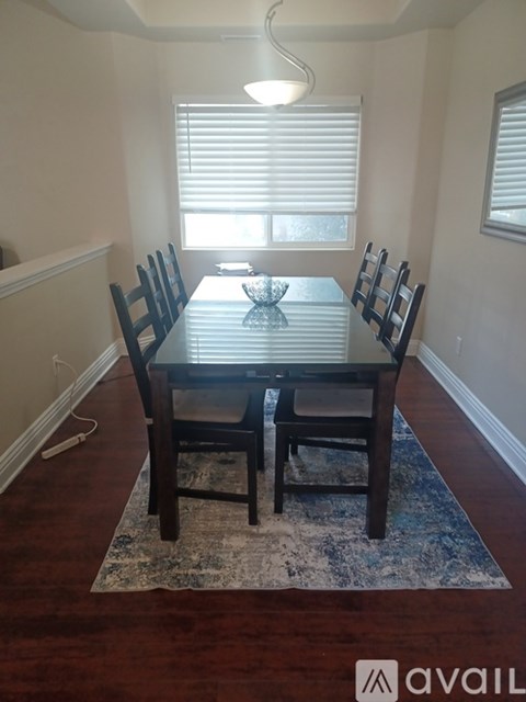 A dining room with a table and chairs.