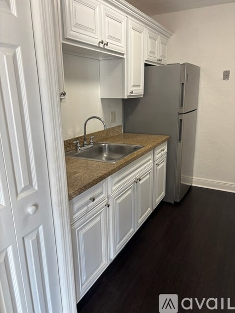 A kitchen with white cabinets and a granite countertop.