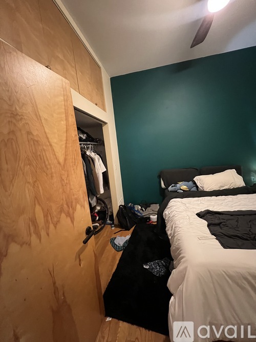 A bedroom with a bed and a ceiling fan.