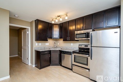 A kitchen with black cabinets and stainless steel appliances.