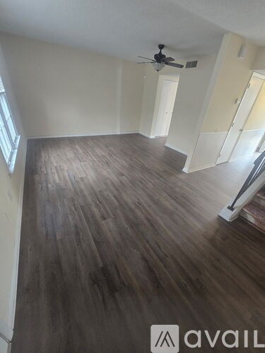 A room with wooden flooring and a ceiling fan.