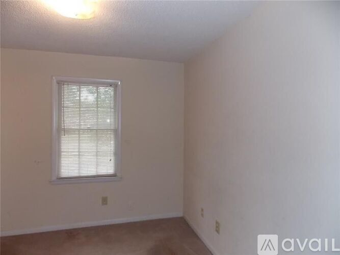 A room with a window and a wall socket.