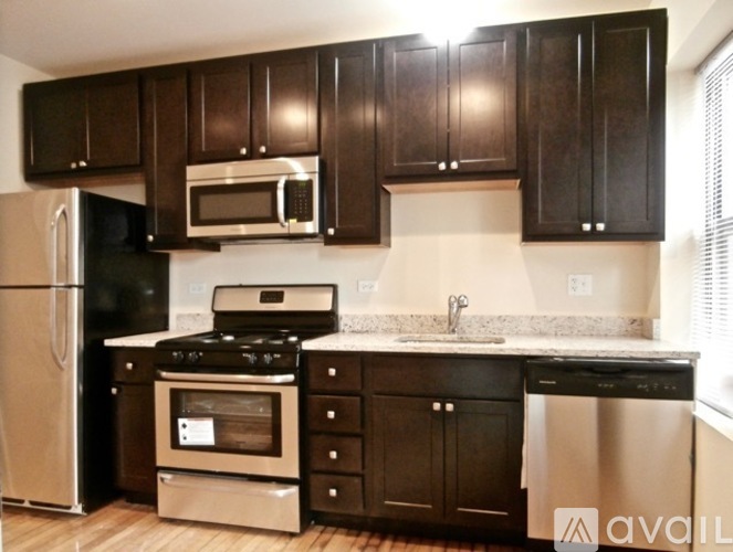A kitchen with black cabinets and stainless steel appliances.