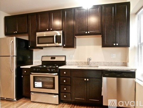 A kitchen with black cabinets and stainless steel appliances.
