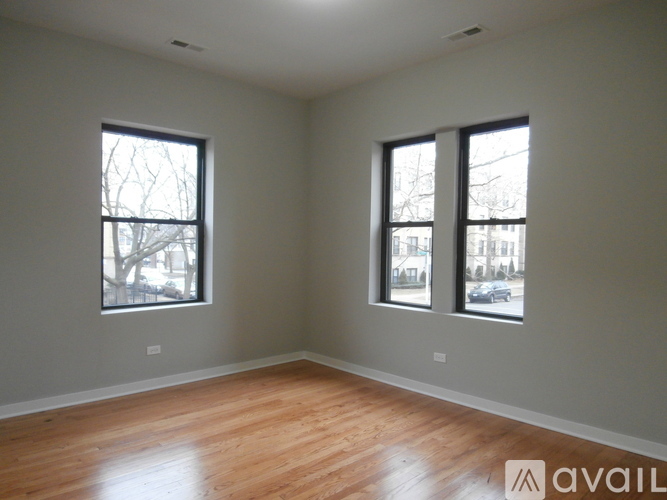 Two windows let in natural light in this empty room.