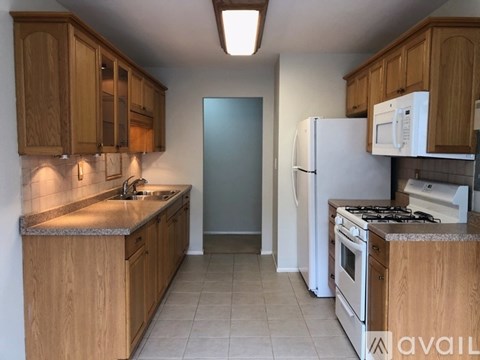 A kitchen with wooden cabinets and a white refrigerator.