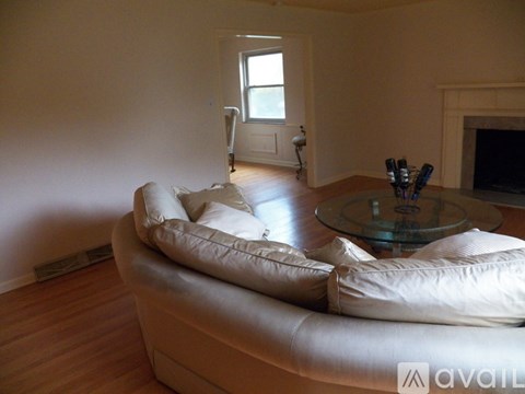 A living room with a white couch and a glass coffee table.