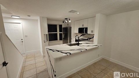 A kitchen with white cabinets and a black stove top oven.
