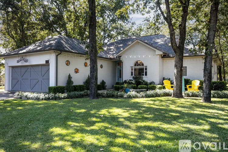 A white house with a black roof and a grey garage door.