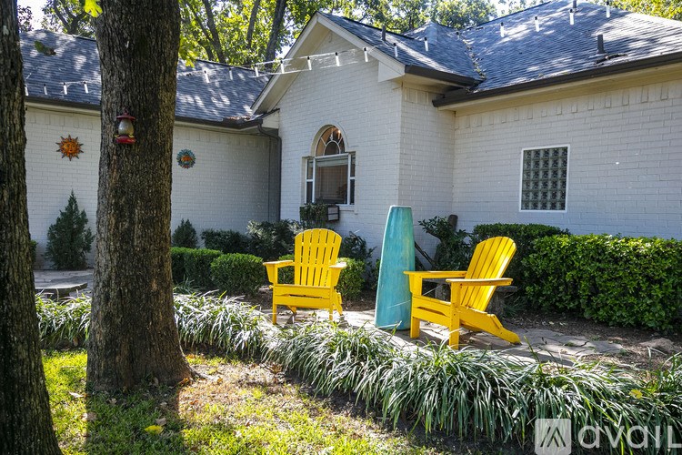 Two yellow chairs are placed on a green lawn.
