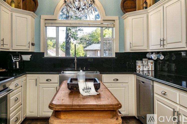 A kitchen with a wooden table in the middle and a window above it.