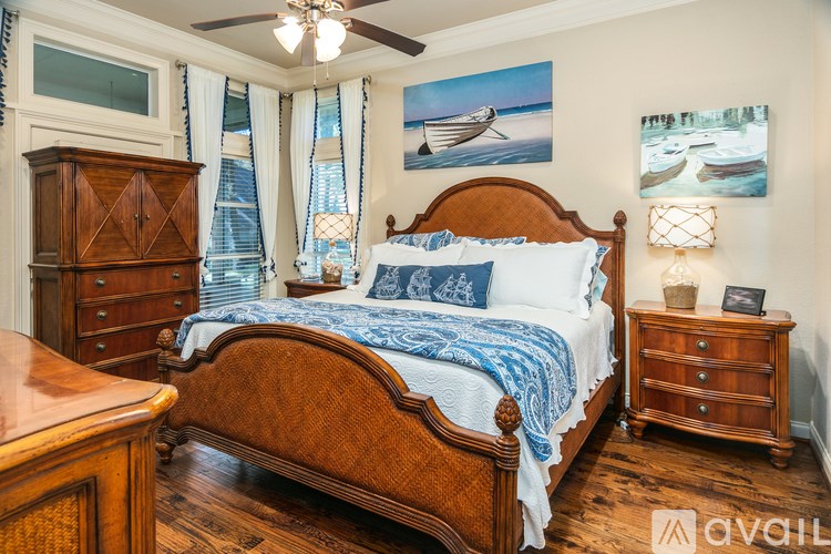 A bedroom with a large bed and a wooden dresser.