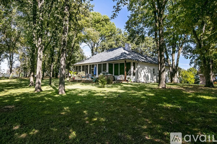 A house with a porch surrounded by trees.