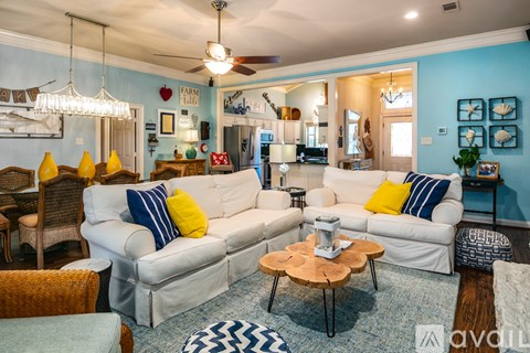 A living room with a white couch and a wooden coffee table.