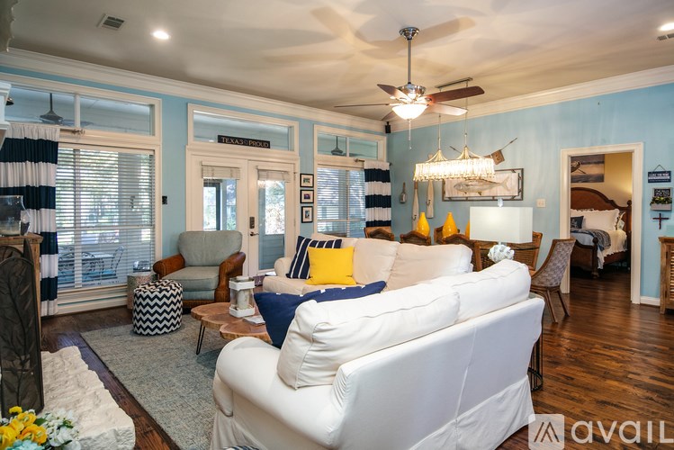 A living room with a white couch and a chandelier.