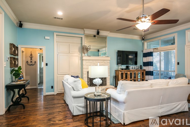 A living room with a white couch and a ceiling fan.