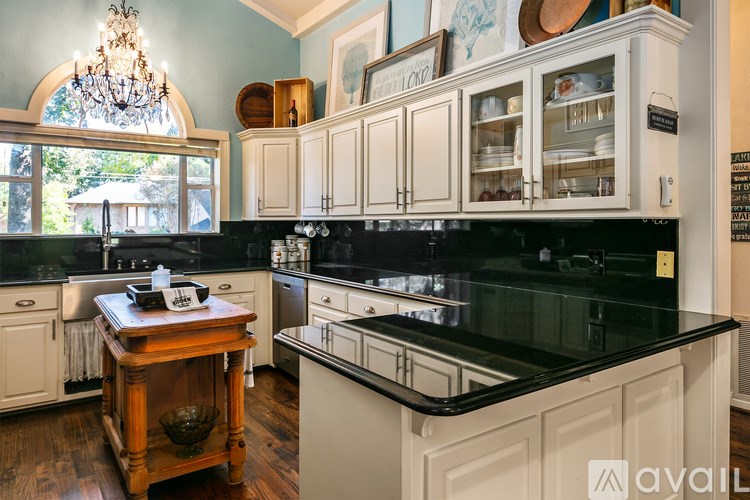 A kitchen with a black countertop and white cabinets.