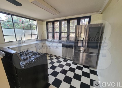A black and white checkered floor in a kitchen with stainless steel appliances.
