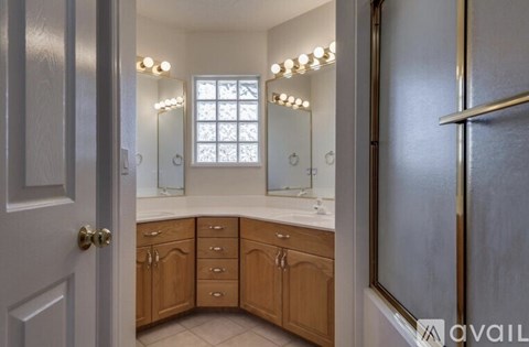 A bathroom with a vanity, a mirror, and lights.