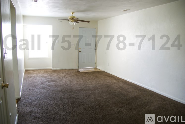 A room with a carpeted floor and a ceiling fan.