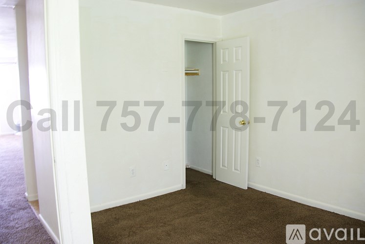 A room with a carpeted floor and a door leading to another room.