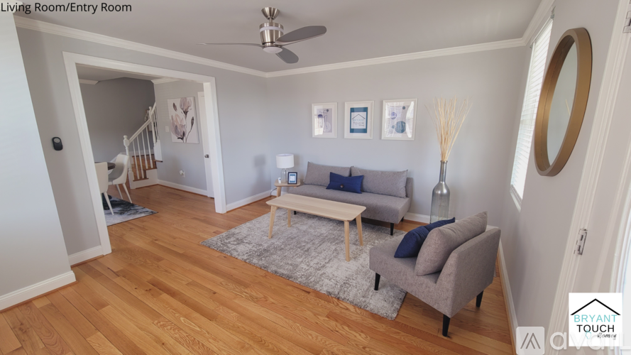 A living room with a grey couch and a grey rug.