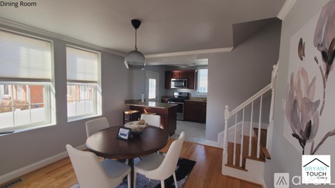 A dining room with a round table and chairs.