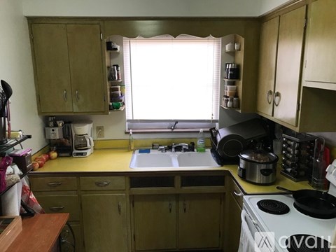 A kitchen with wooden cabinets and a white stove top.