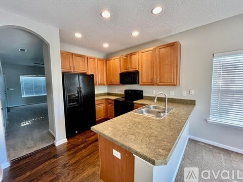 A kitchen with wooden cabinets and black appliances.