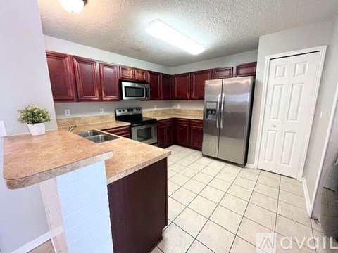 A kitchen with red cabinets and a white door.