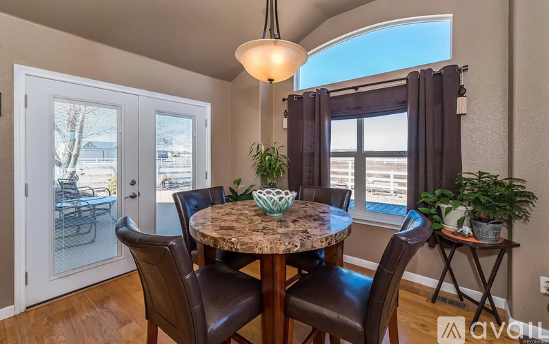 A dining room with a round table and chairs.