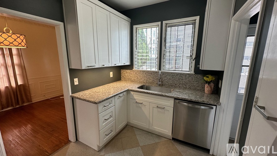 A kitchen with white cabinets and a granite countertop.