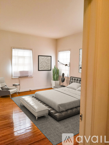 A bedroom with a bed, chair, and a plant.