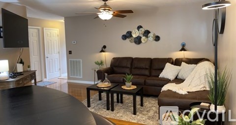 A living room with a brown couch and a black coffee table.