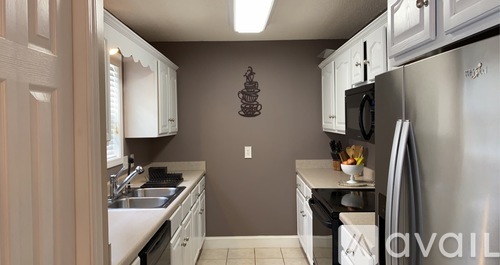 A kitchen with a stainless steel refrigerator and white cabinets.