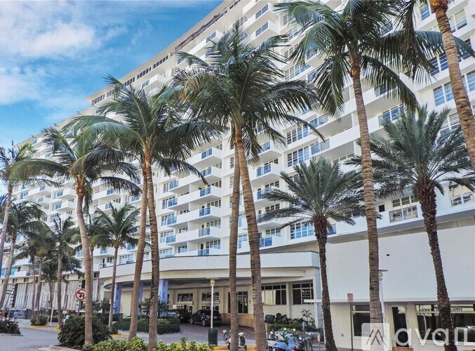 Palm trees in front of a white building.