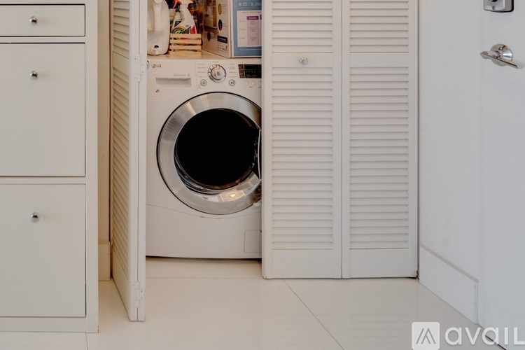 A white washing machine is in a small laundry room.
