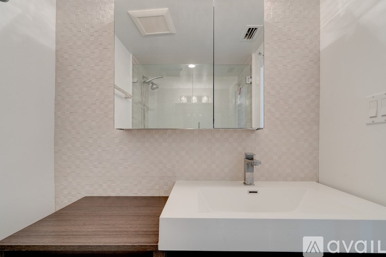 A modern bathroom with a white tub and a wooden floor.