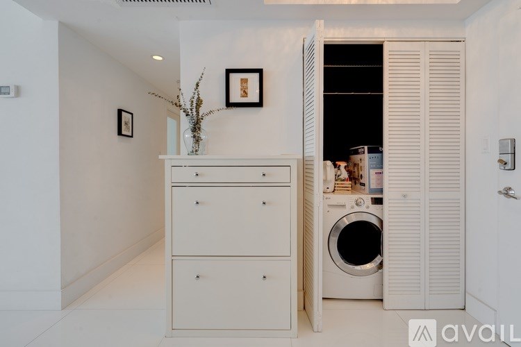 A white cabinet with a vase of flowers on top of it.