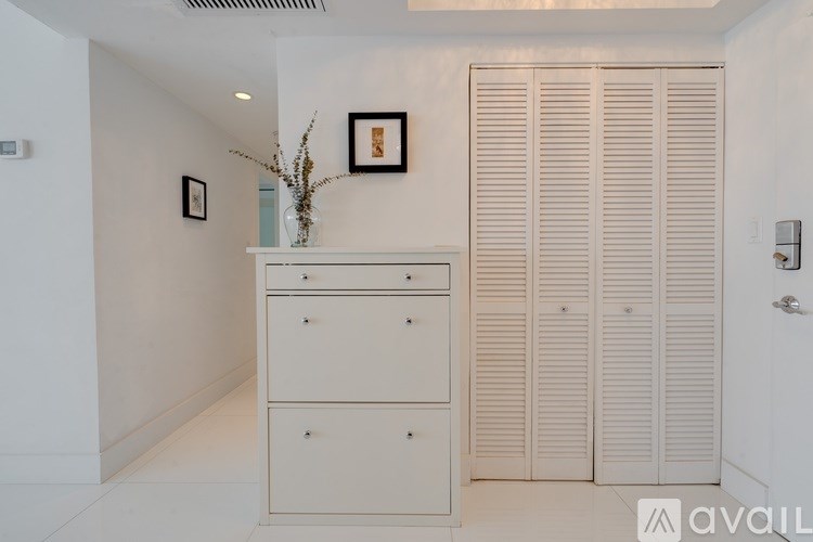 Closed white shutter doors in a white room.